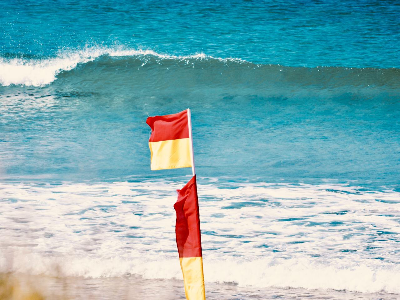 Waarschuwingsvlag rood en geel op het strand