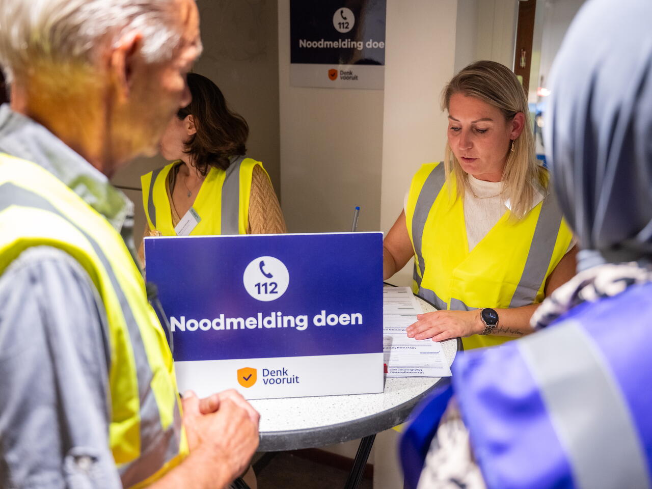 Een foto van mensen die een noodmelding willen doen bij een noodsteunpunt