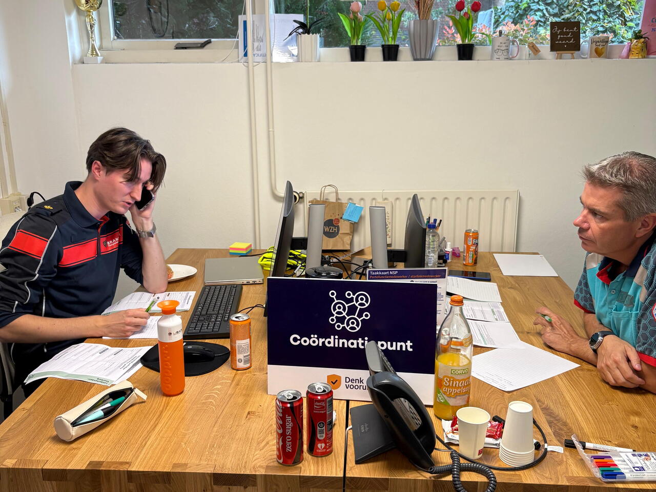 Een foto van een brandweercentralist en ambulancecentralist op het coordinatiepunt